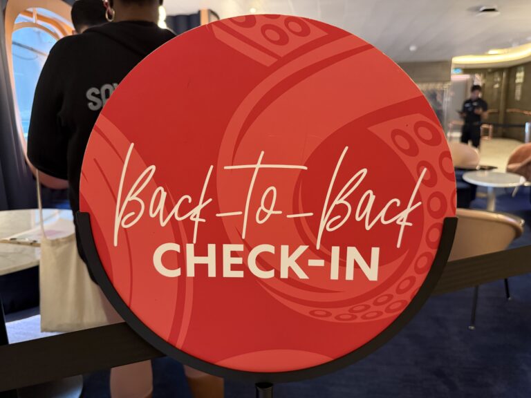 Red Virgin Voyages Back‑to‑Back check‑in sign displayed in the SIP Lounge onboard the ship.