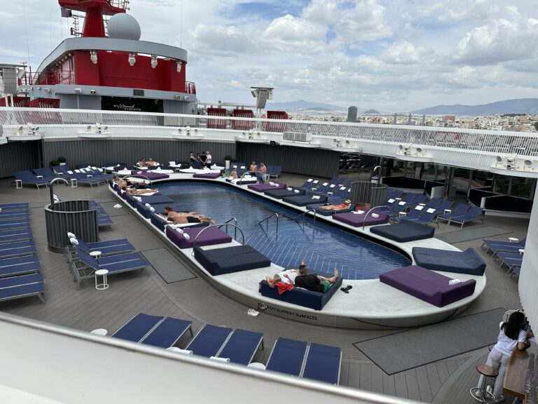Virgin Voyages Aquatic Club pool deck featuring the main swimming pool, luxury loungers, day beds and adults-only relaxation areas onboard.