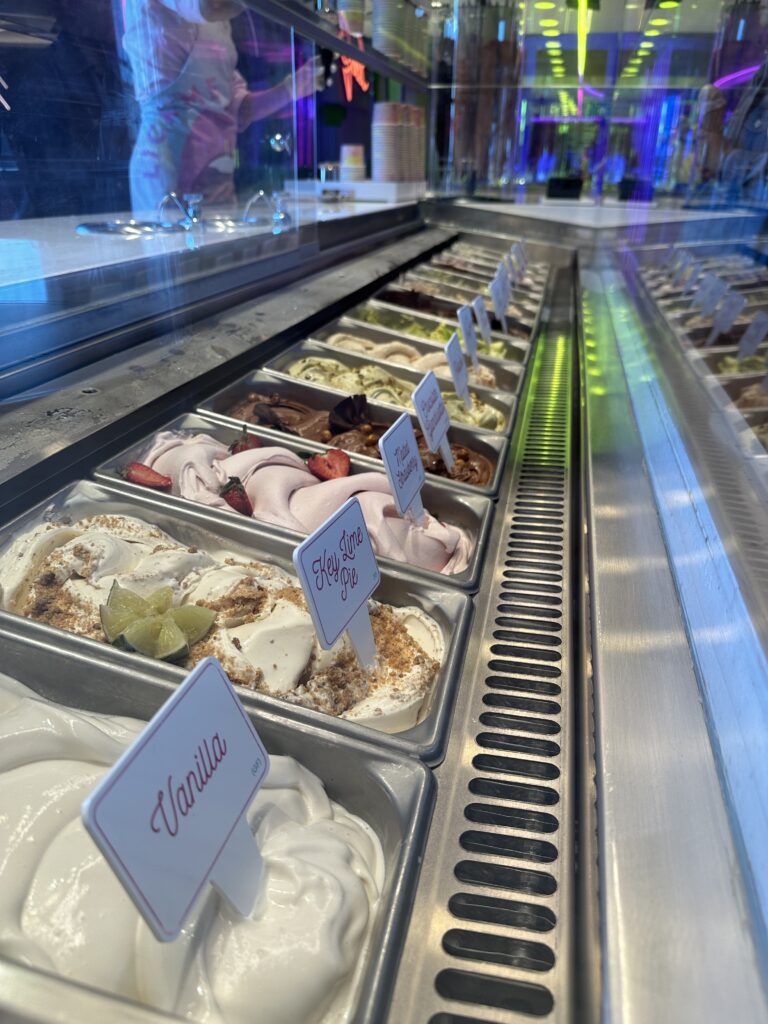Selection of complimentary gelato and ice cream flavours at Lick Me Till Ice Cream aboard Virgin Voyages, including vanilla, key lime pie and fruit-inspired desserts.