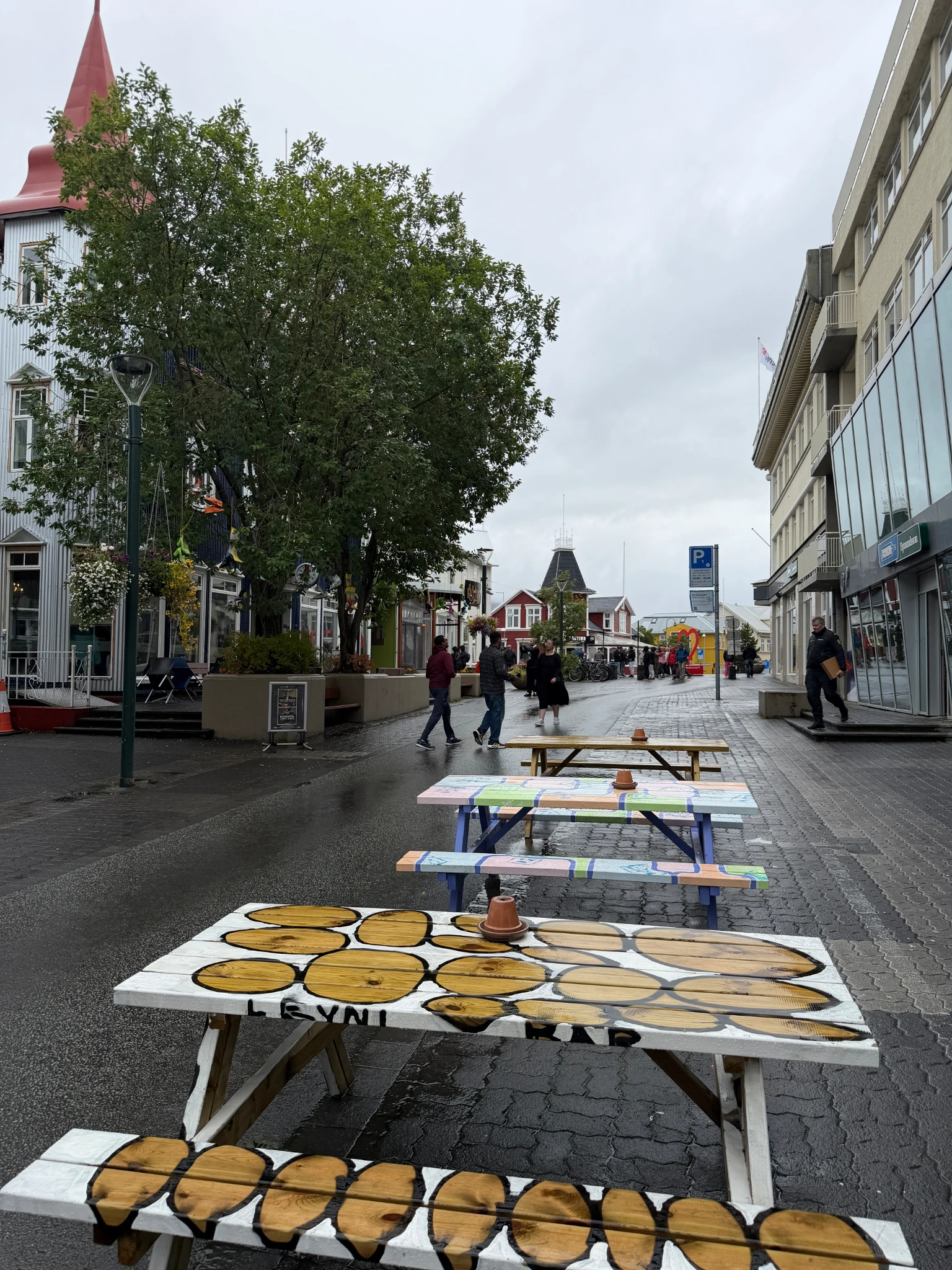 Pedestrian street in Akureyri town centre featuring colourful buildings, outdoor seating and local shops, visited by Virgin Voyages guests exploring northern Iceland.